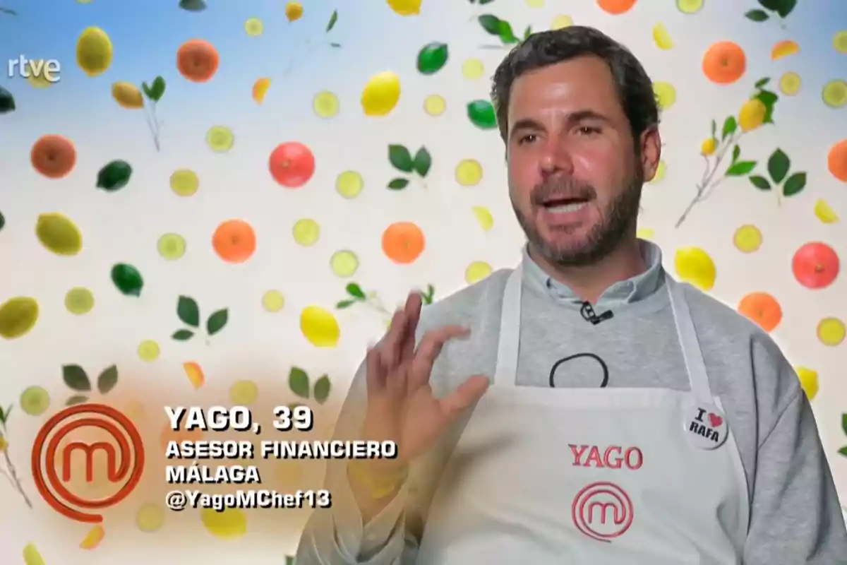 Yago amb un davantal blanc amb el nom Yago i una xapa que diu I love Rafa, parlant davant d’un fons decorat amb fruites i fulles, en una entrevista d’un programa de cuina. Captura de 'MasterChef' Yago amb un davantal blanc amb el nom Yago i una xapa que diu I love Rafa, parlant davant d’un fons decorat amb fruites i fulles, en una entrevista d’un programa de cuina. Captura de 'MasterChef'