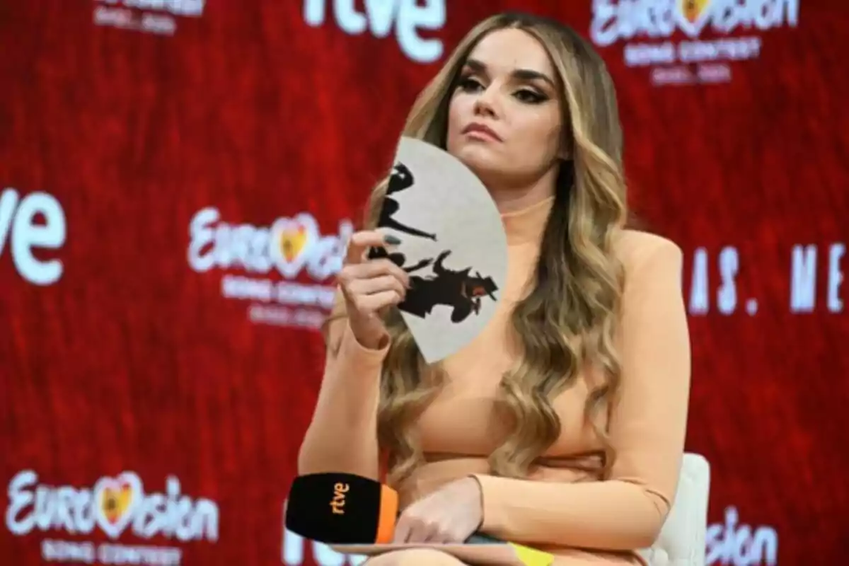 Melody sostenint un ventall i amb rostre seriós durant la roda de premsa oferida després del seu pas per Eurovisió, el 26 de maig de 2025, a Madrid. Melody sostenint un ventall i amb rostre seriós durant la roda de premsa oferida després del seu pas per Eurovisió, el 26 de maig de 2025, a Madrid.