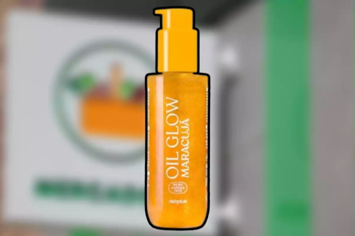 Ampolla d’oli corporal Oil Glow Maracujà de color taronja amb dispensador, sobre un fons desenfocat Ampolla d’oli corporal Oil Glow Maracujà de color taronja amb dispensador, sobre un fons desenfocat