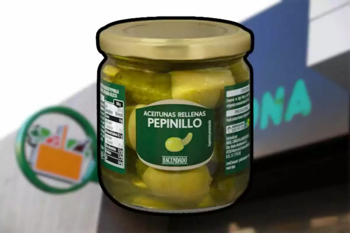 Un pot d'olives farcides de cogombre de la marca Hacendado davant d'un cartell borros de supermercat. Un pot d'olives farcides de cogombre de la marca Hacendado davant d'un cartell borros de supermercat.