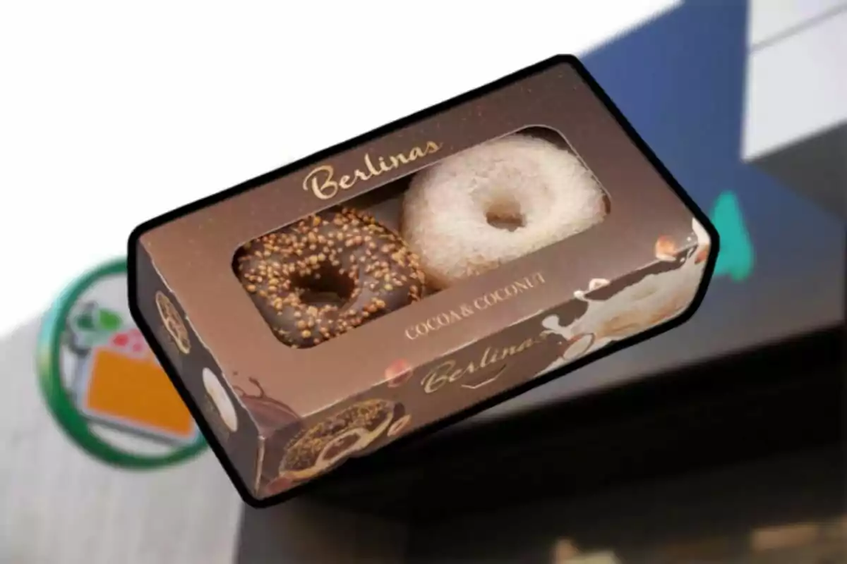 Caja de donas Berlina con sabores de cacao y coco en un fondo borroso.