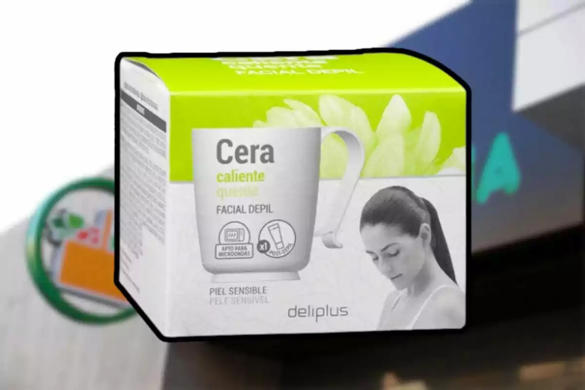 Caixa de cera facial depilatòria calenta per a pell sensible de la marca Deliplus amb fons desenfocat de supermercat Caixa de cera facial depilatòria calenta per a pell sensible de la marca Deliplus amb fons desenfocat de supermercat