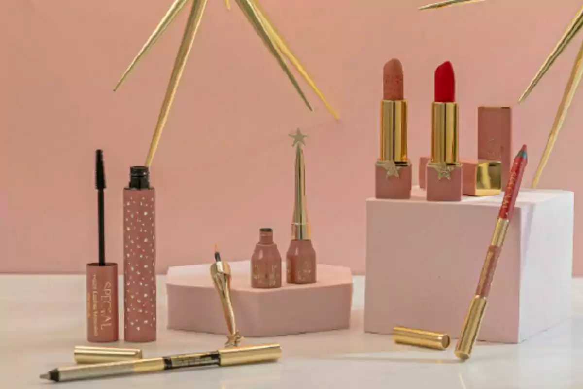 Productos de maquillaje en un fondo rosa, incluyendo labiales, máscara de pestañas y delineadores.