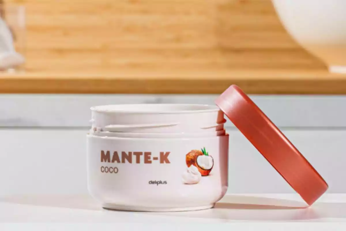 Un envàs de crema de coco amb tapa vermella està obert sobre una superfície blanca, mostrant el seu contingut cremós. Un envàs de crema de coco amb tapa vermella està obert sobre una superfície blanca, mostrant el seu contingut cremós.