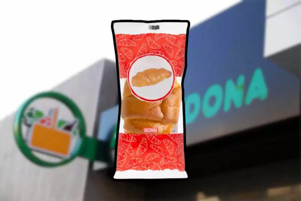 Paquet de pa dolç amb disseny de croissants en un fons que mostra part d'un rètol de supermercat. Paquet de pa dolç amb disseny de croissants en un fons que mostra part d'un rètol de supermercat.