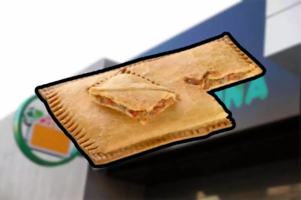 Empanada rectangular amb farcit de carn i vegetals davant d'un rètol de botiga Empanada rectangular amb farcit de carn i vegetals davant d'un rètol de botiga
