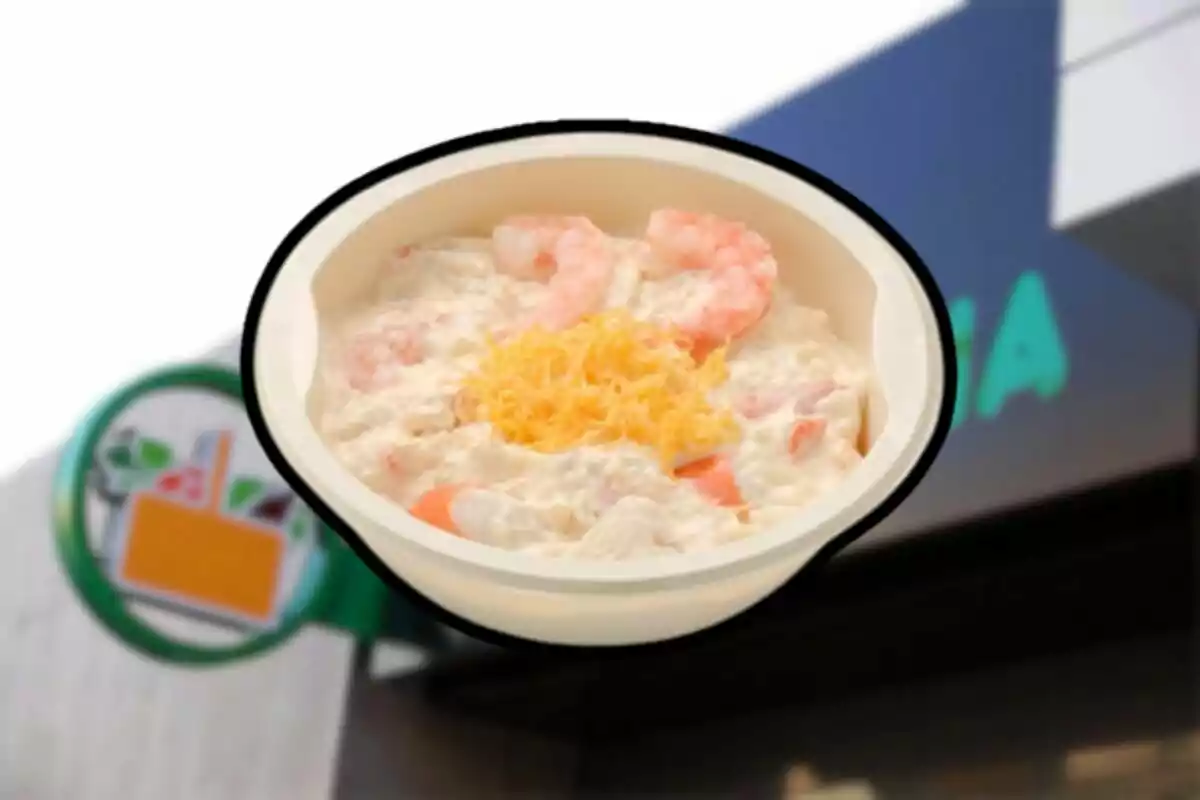 Un bol d'amanida de marisc amb gambes i formatge ratllat a la part superior davant d'un rètol de botiga. Un bol d'amanida de marisc amb gambes i formatge ratllat a la part superior davant d'un rètol de botiga.