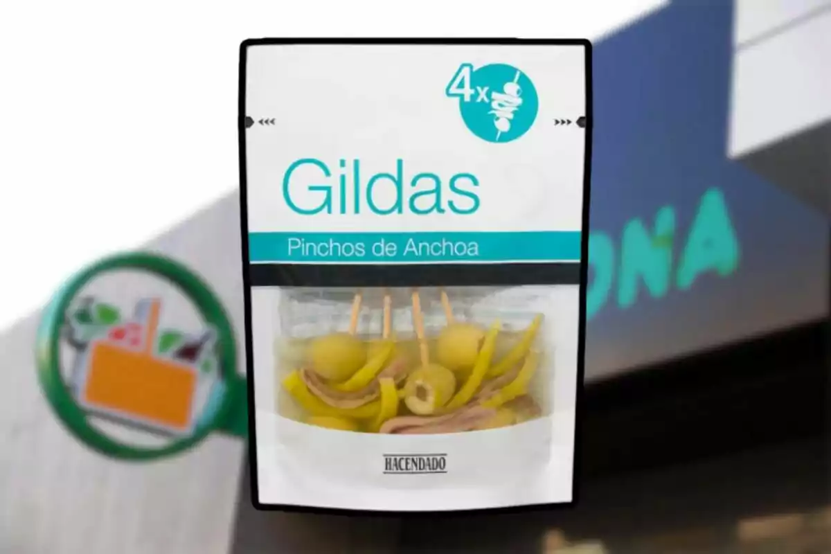 Paquete de gildas pinchos de anchoa de la marca Hacendado frente a un supermercado Mercadona desenfocado. Paquete de gildas pinchos de anchoa de la marca Hacendado frente a un supermercado Mercadona desenfocado.