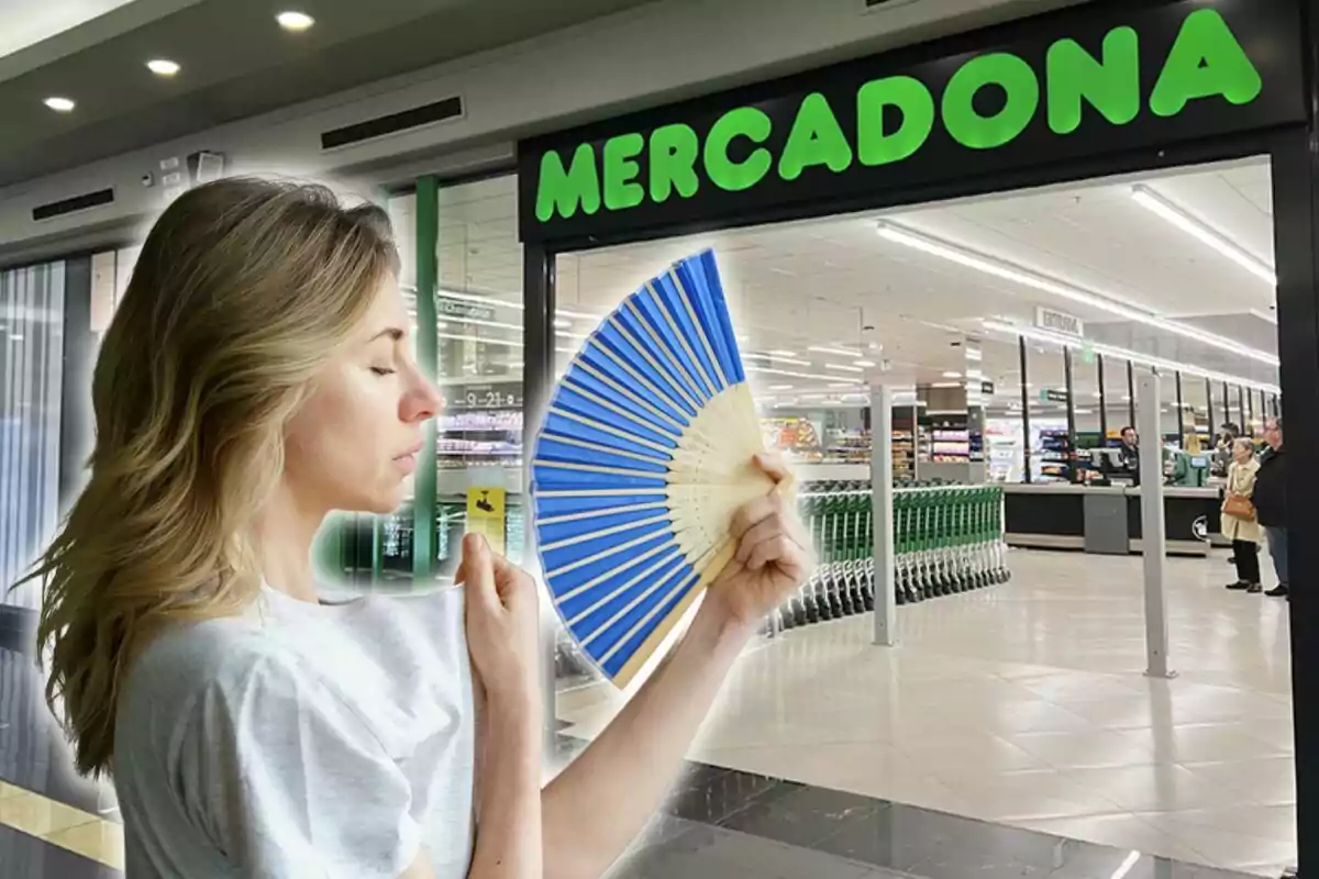 Una dona amb un ventall blau es troba davant de l'entrada d'un supermercat.
