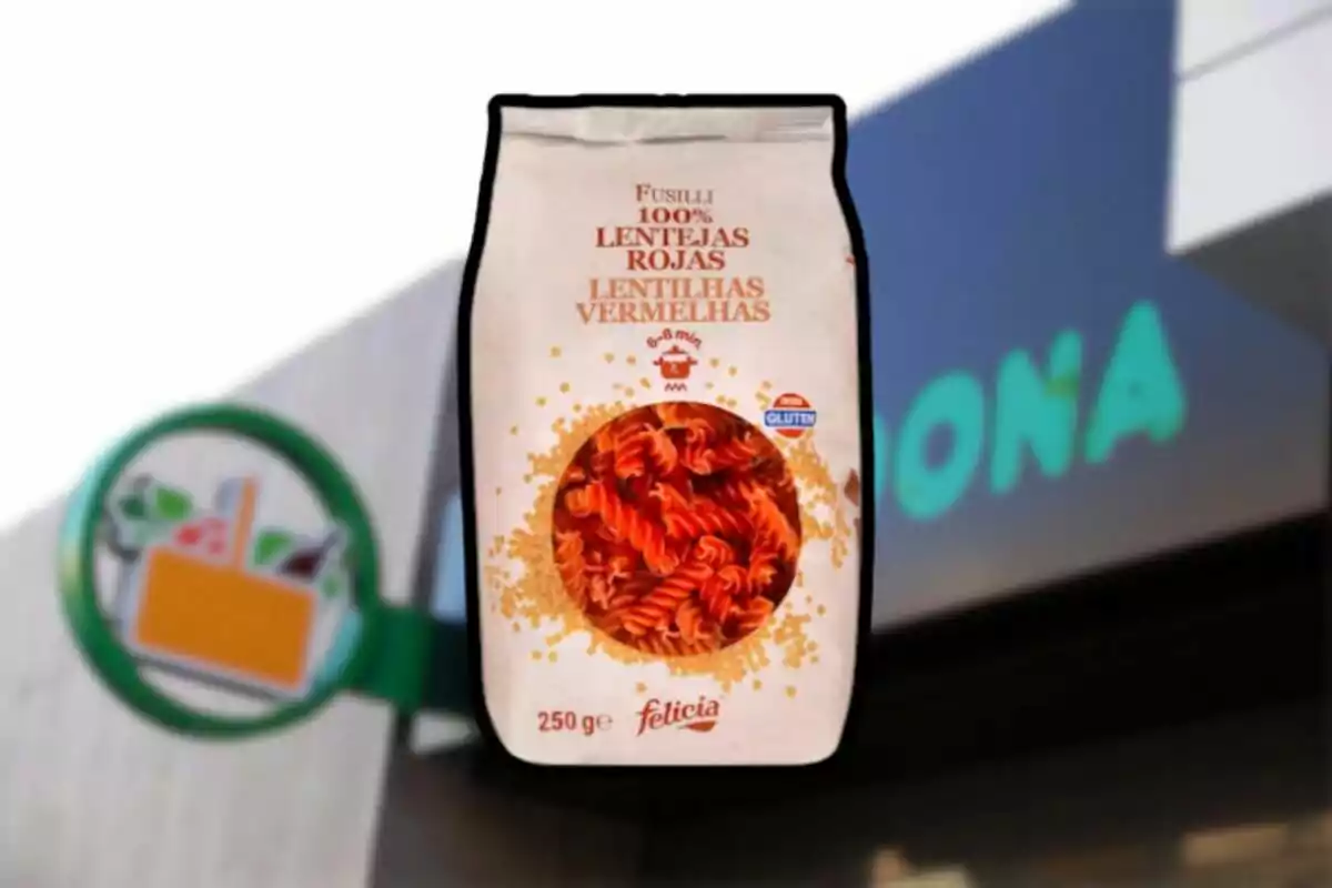 Paquet de fusilli de llenties vermelles sense gluten davant d'un cartell de supermercat. Paquet de fusilli de llenties vermelles sense gluten davant d'un cartell de supermercat.