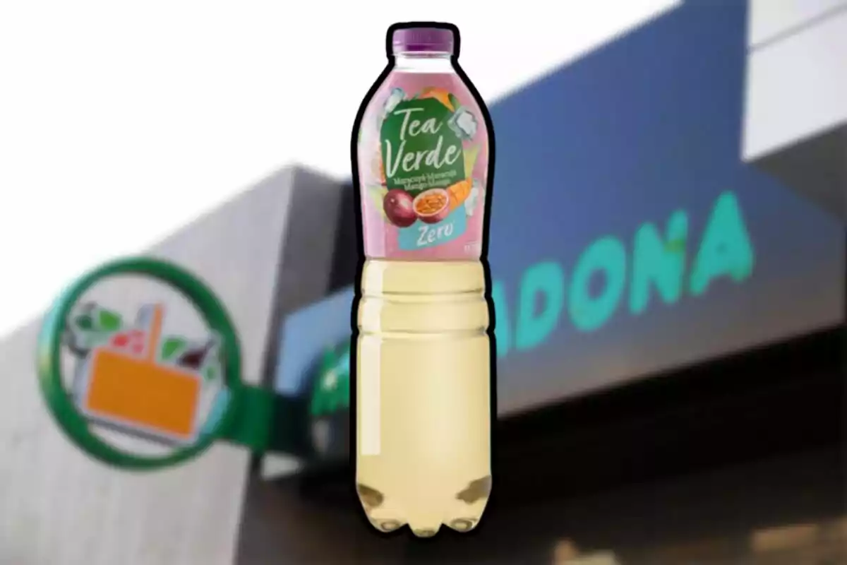 Ampolla de te verd amb gust de maracujà i mango amb etiqueta rosa davant d’una botiga Mercadona desenfocada Ampolla de te verd amb gust de maracujà i mango amb etiqueta rosa davant d’una botiga Mercadona desenfocada