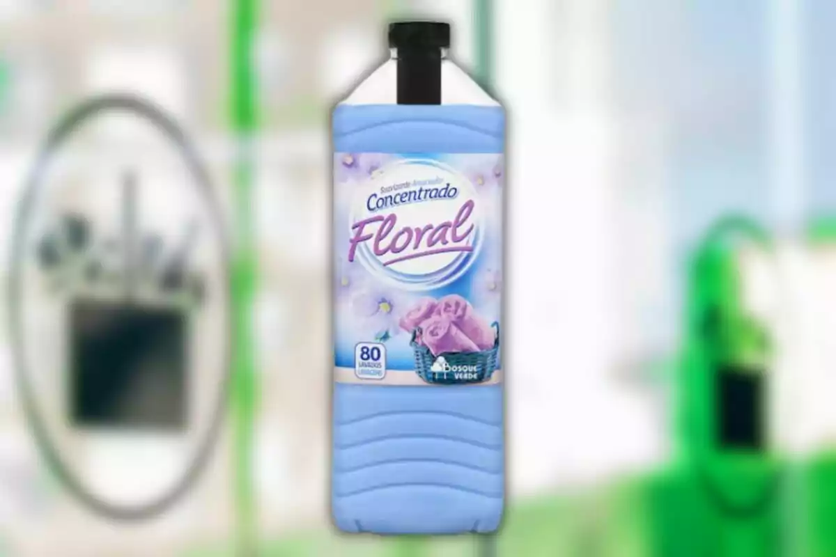 Ampolla de suavitzant concentrat floral de color blau amb etiqueta que mostra tovalloles roses i flors Ampolla de suavitzant concentrat floral de color blau amb etiqueta que mostra tovalloles roses i flors