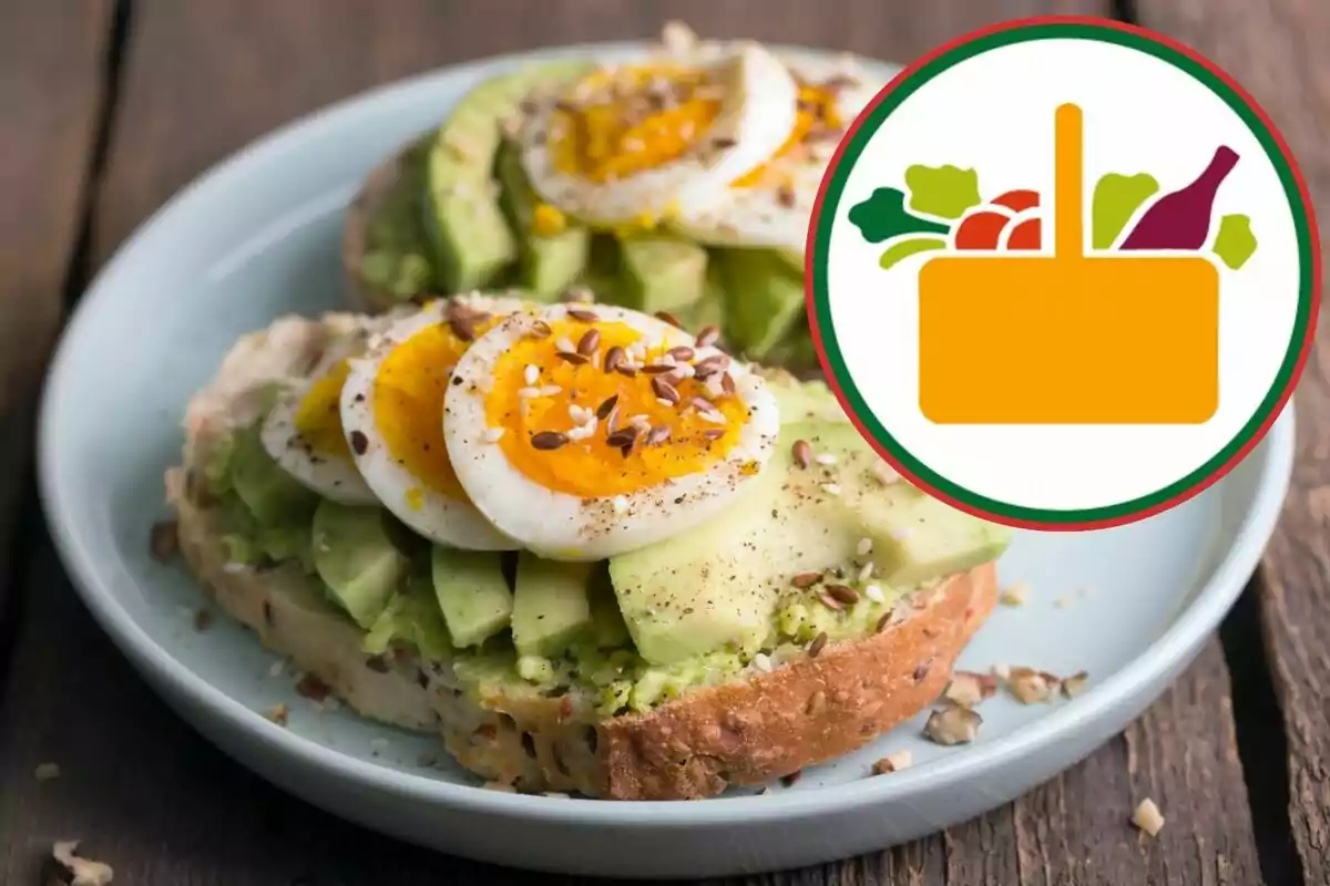 Torrada d'alvocat amb ou dur i llavors en un plat blanc al costat d'una icona de cistella d'aliments. Torrada d'alvocat amb ou dur i llavors en un plat blanc al costat d'una icona de cistella d'aliments.