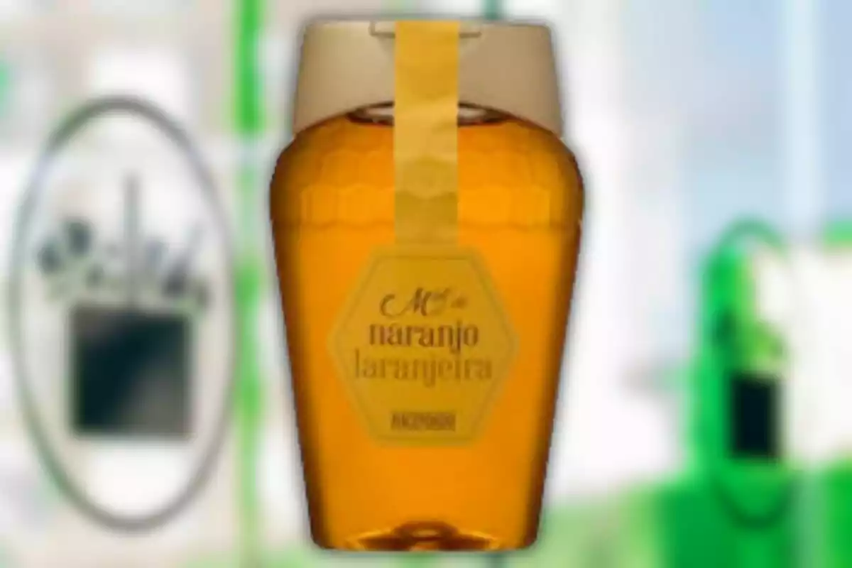 Envàs de mel de taronger amb tapa beix i etiqueta hexagonal sobre un fons desenfocat Envàs de mel de taronger amb tapa beix i etiqueta hexagonal sobre un fons desenfocat