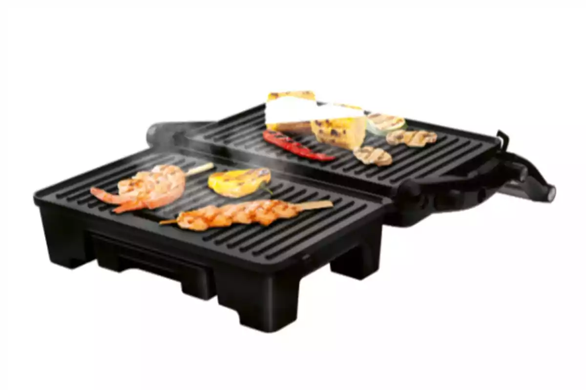 Graella elèctrica amb aliments rostint-se com broquetes, gambes, pebrots, blat de moro, carbassó i formatge Graella elèctrica amb aliments rostint-se com broquetes, gambes, pebrots, blat de moro, carbassó i formatge