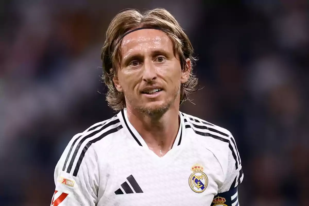 A soccer player in a black and white Real Madrid uniform on the field.