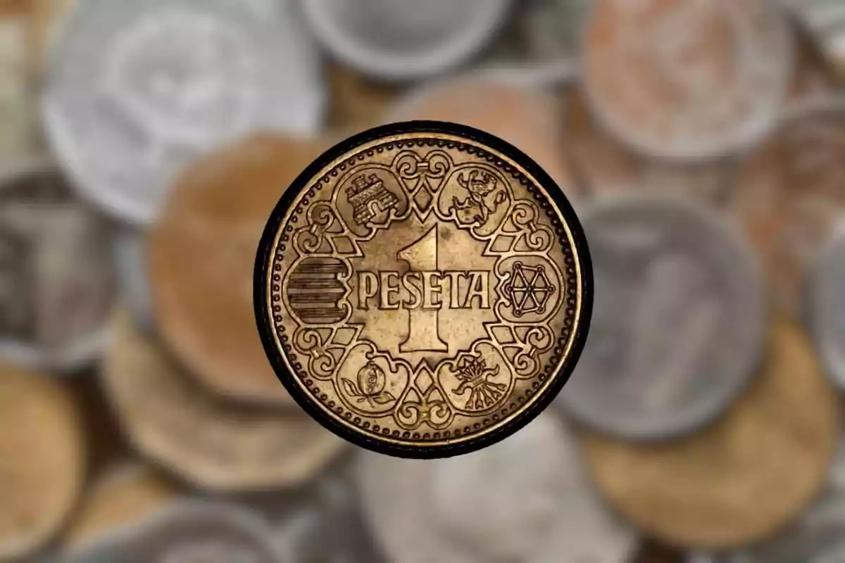 Moneda antiga d'una pesseta amb detalls decoratius al fons d'altres monedes desenfocades. Moneda antiga d'una pesseta amb detalls decoratius al fons d'altres monedes desenfocades.