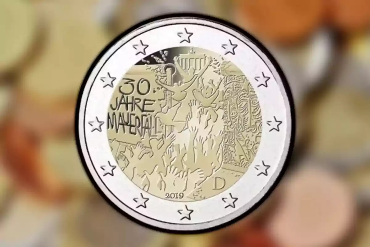 Moneda commemorativa de 2 euros que celebra el 30è aniversari de la caiguda del Mur de Berlín amb un disseny que mostra mans aixecades i la Porta de Brandenburg.