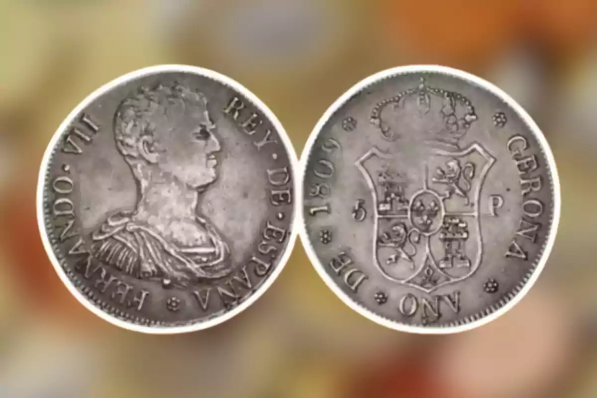 Moneda antiga de plata amb el perfil d'un monarca i un escut heràldic al revers. Moneda antiga de plata amb el perfil d'un monarca i un escut heràldic al revers.