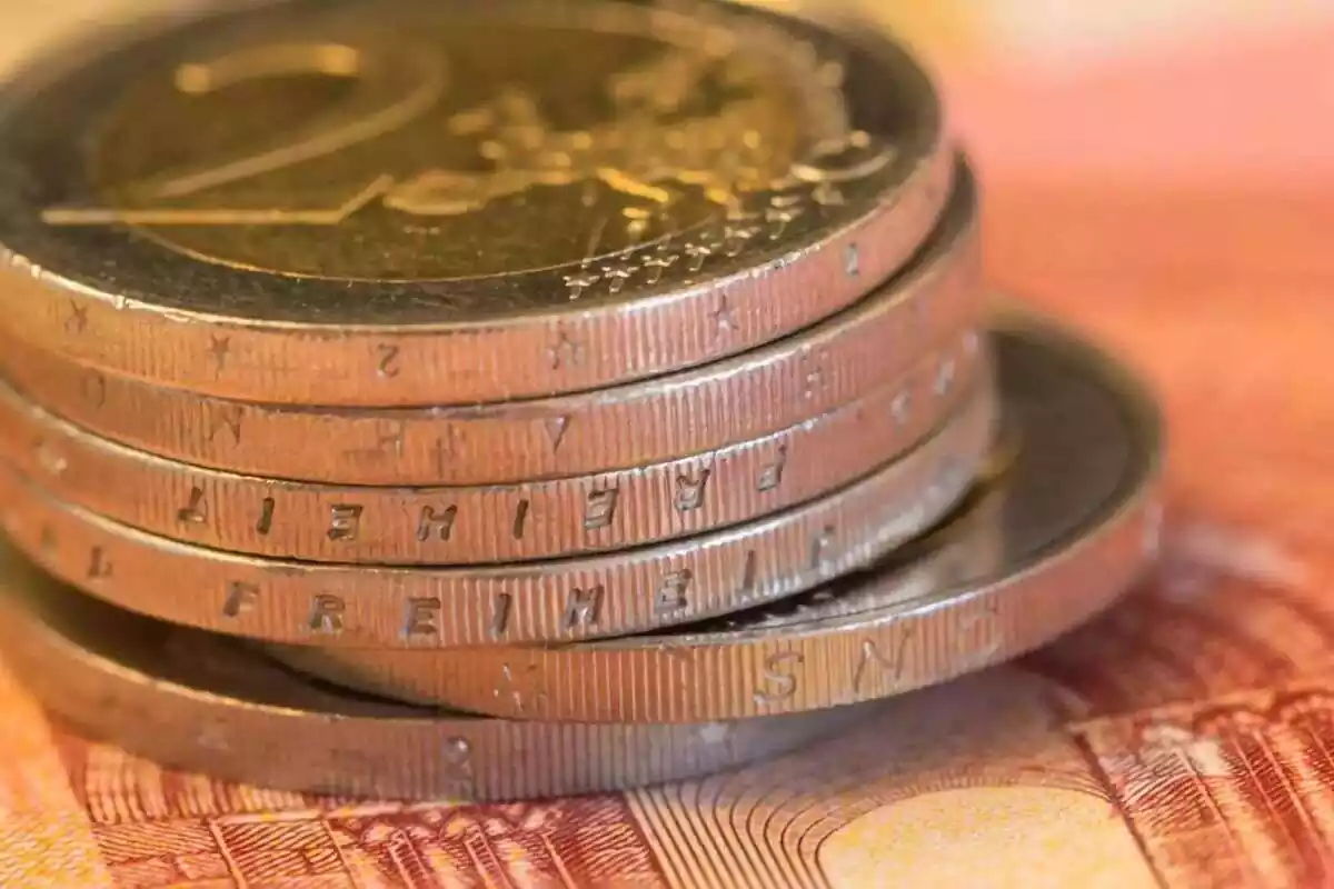 PrPrimer pla de sis monedes de dos euros amuntegades sobre un bitllet