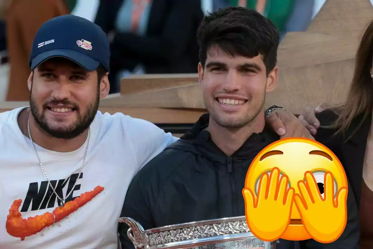 Álvaro Alcaraz i Carlos Alcaraz somrients posen junts, Álvaro porta una gorra i una samarreta blanca amb el logo de Nike, mentre que Carlos sosté un trofeu i té un emoji cobrint part de la cara.