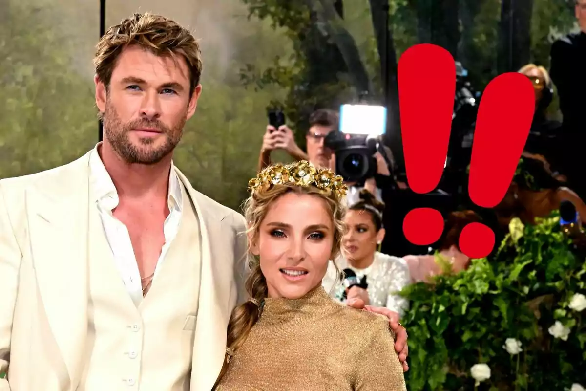 Chris Hemsworth and Elsa Pataky posing elegantly at an event with a background of photographers and a large red exclamation mark.