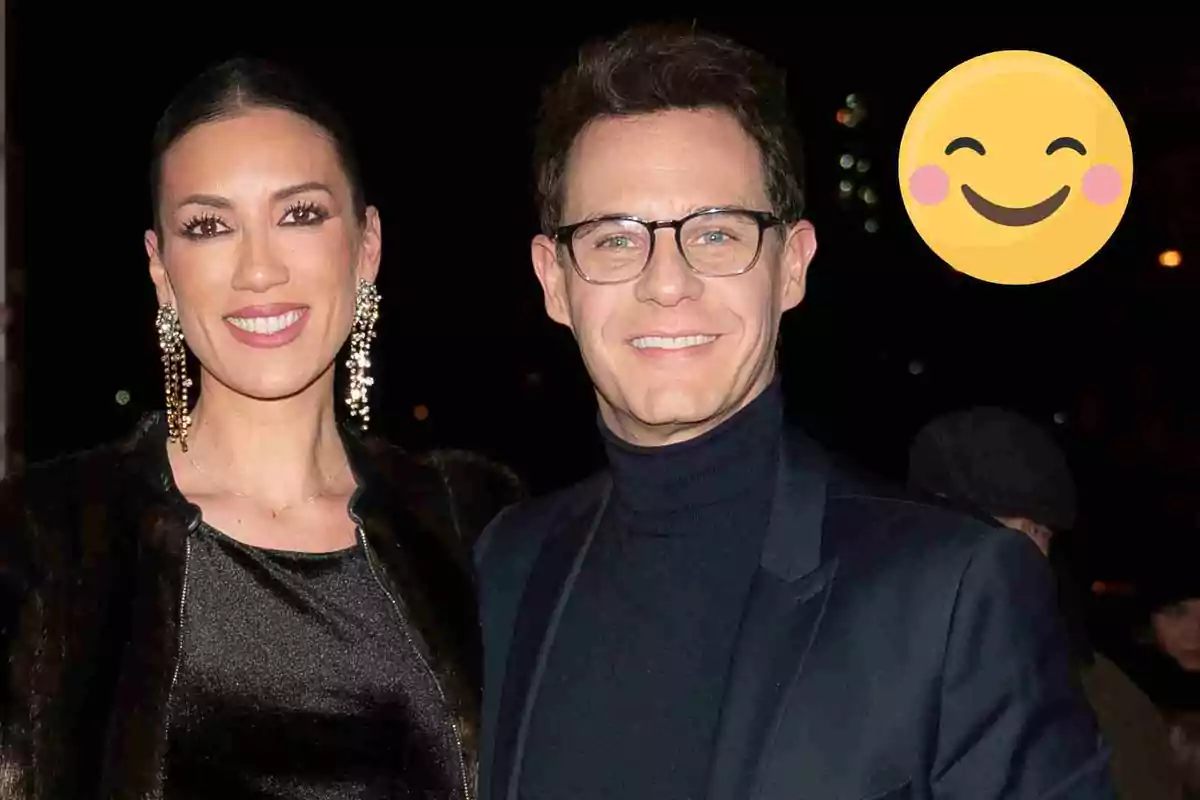 Patricia Pardo y Christian Gálvez posant per a una foto en un esdeveniment nocturn amb un emoji somrient a la cantonada superior dreta.