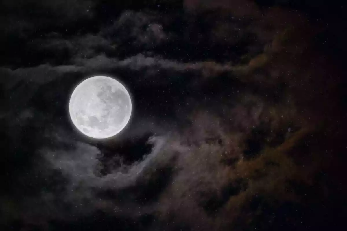 Un cel de nit fosca amb núvols, estrelles i la lluna plena Un cel de nit fosca amb núvols, estrelles i la lluna plena