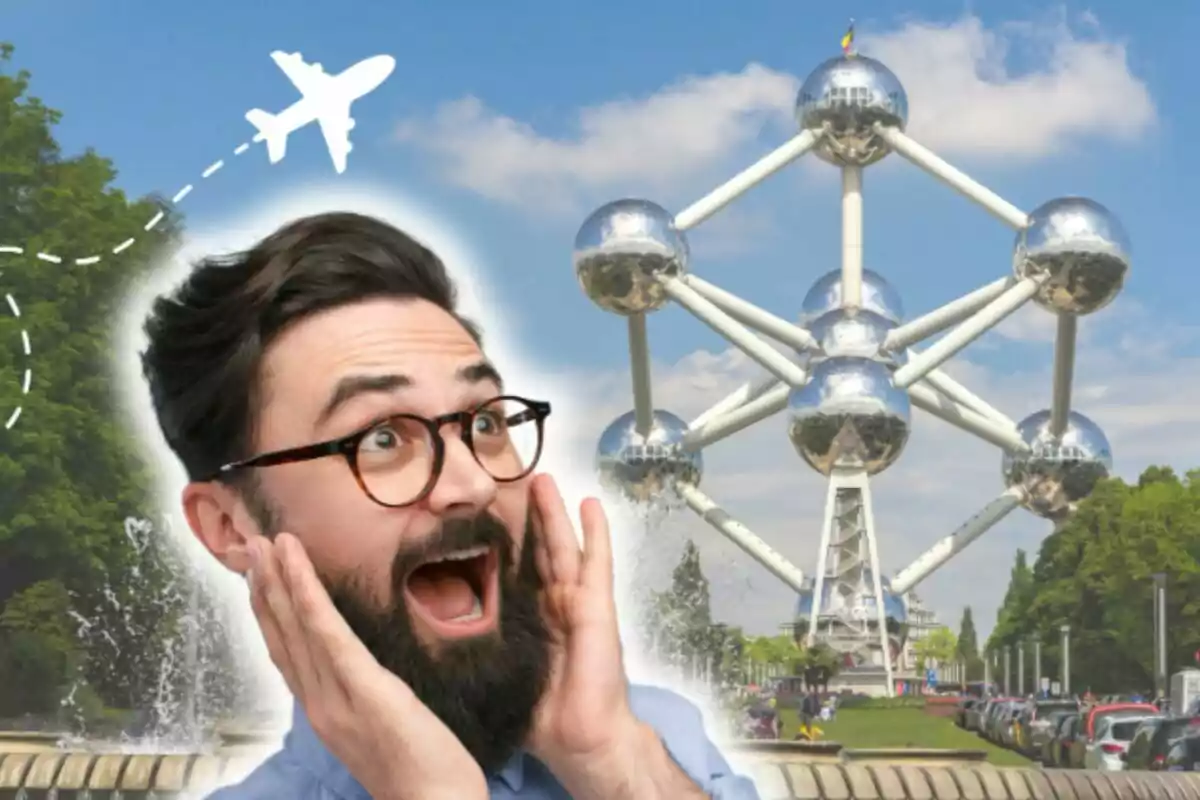 Home sorprès amb barba i ulleres davant de l'Atomium a Brussel·les amb un avió dibuixat al cel.