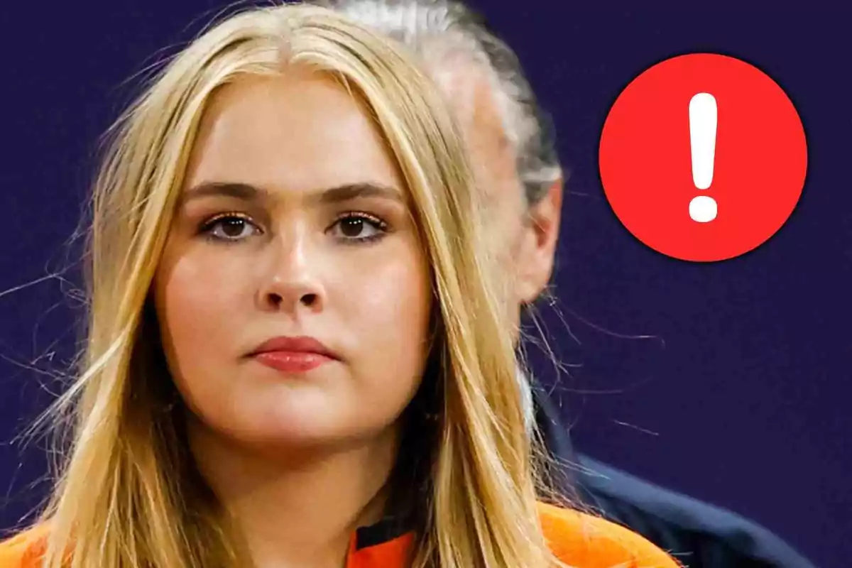 Amàlia d'Holanda amb expressió seriosa i un cercle vermell amb un signe d’exclamació blanc al fons