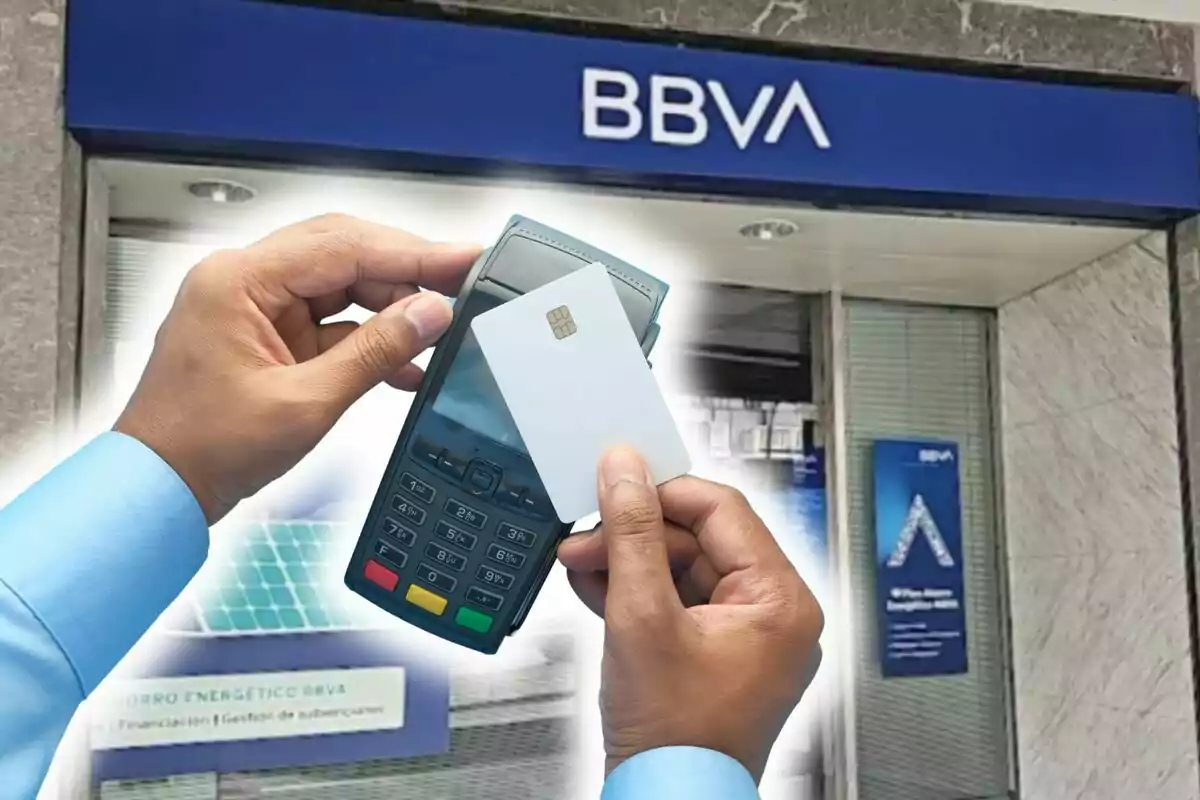 Persona sostenint una terminal de pagament i una targeta davant d'una sucursal de BBVA.