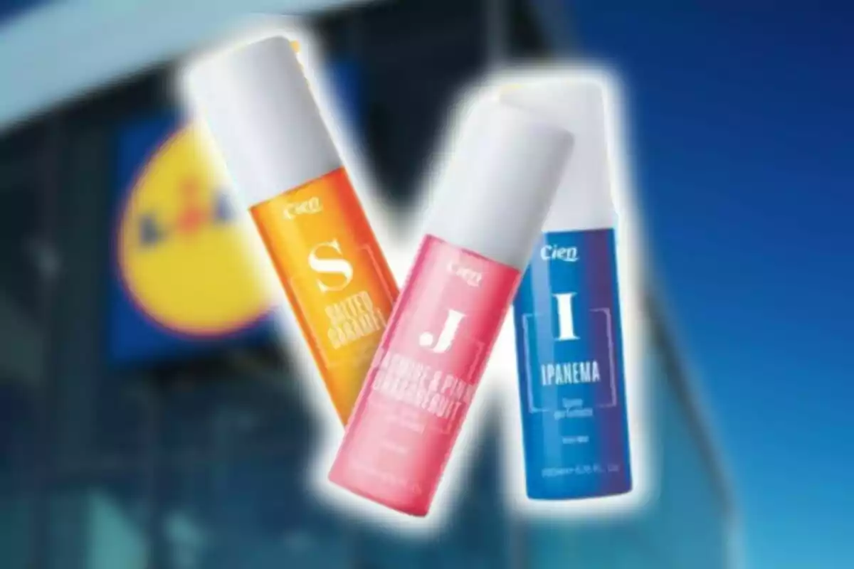 Tres flascons de body mist de la marca Cien en colors taronja, rosa i blau davant d’una botiga Lidl desenfocada. Tres flascons de body mist de la marca Cien en colors taronja, rosa i blau davant d’una botiga Lidl desenfocada.