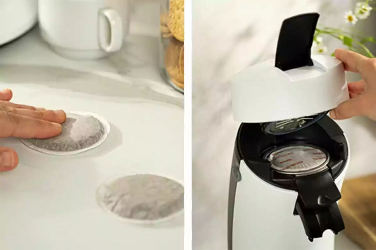 Una mà col·loca una càpsula de cafè en una superfície mentre una altra mà obre una cafetera per inserir la càpsula. Una mà col·loca una càpsula de cafè en una superfície mentre una altra mà obre una cafetera per inserir la càpsula.