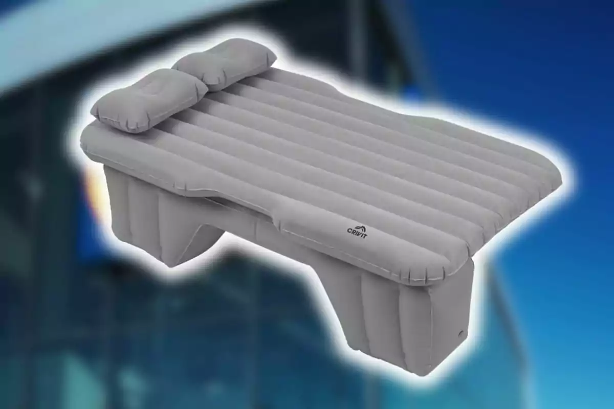 Llit inflable gris de Lidl amb dos coixins sobre un fons blau. Llit inflable gris de Lidl amb dos coixins sobre un fons blau.