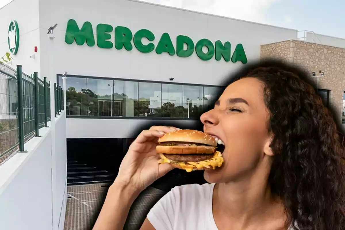 Una persona menjant una hamburguesa davant d'un supermercat Mercadona.