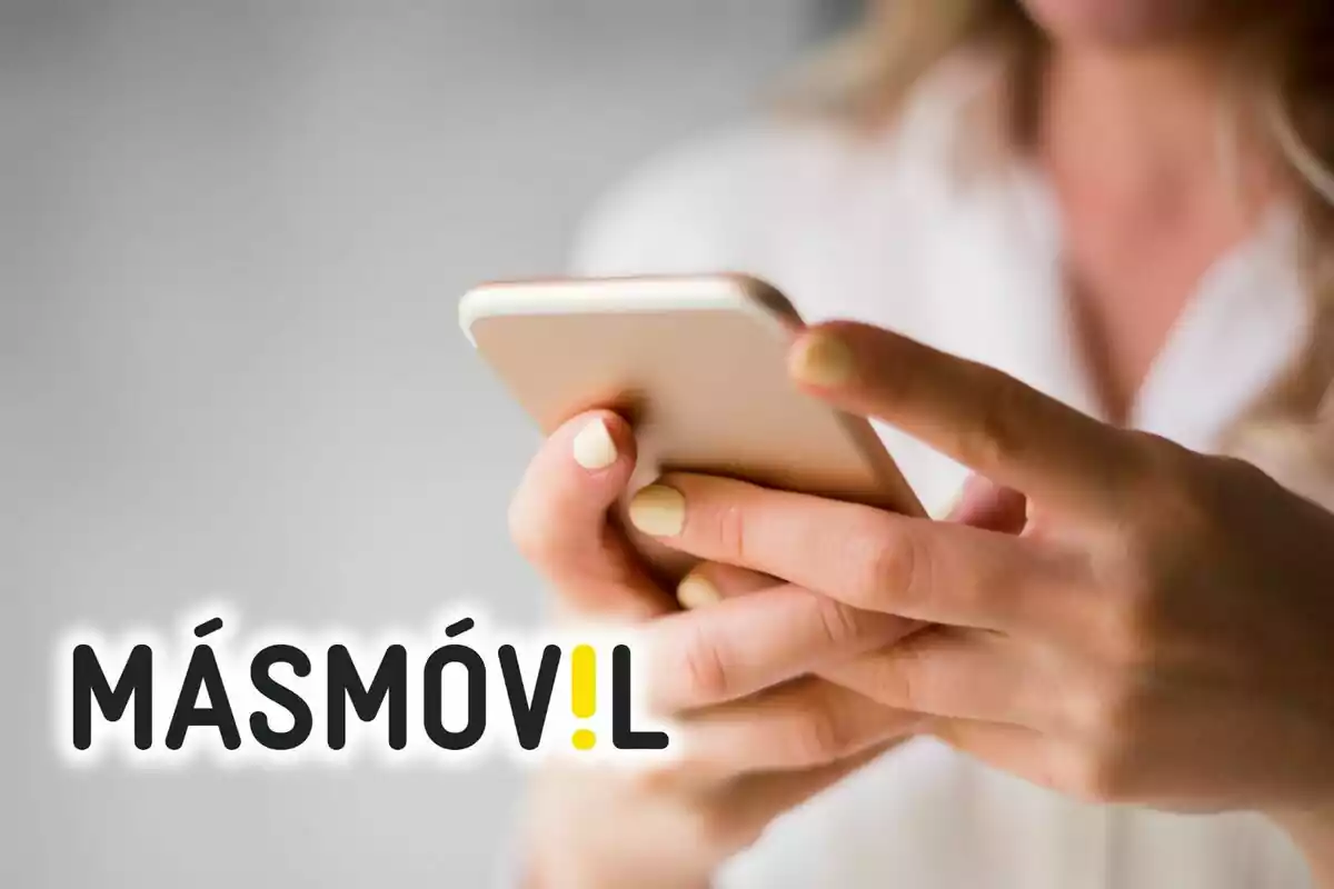 Persona usant un telèfon mòbil amb el logotip de MásMóvil en primer pla.