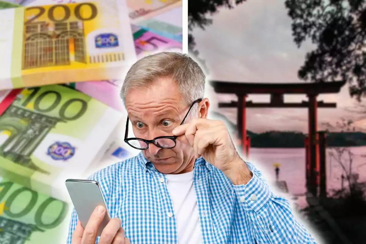 Un home gran amb camisa a quadres blaus i blanques mira sorprès el telèfon mòbil, amb bitllets d'euro i un paisatge amb un torii japonès de fons.