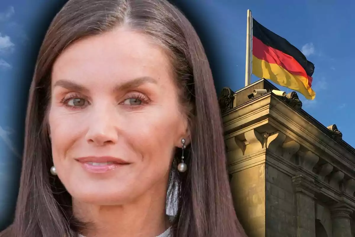 Close-up of Letizia Ortiz wearing pearl earrings next to a building with a German flag waving at the top.
