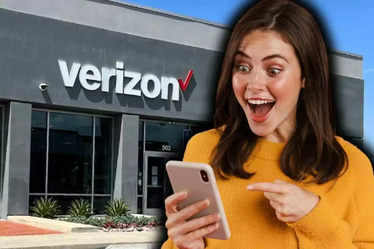 Una dona emocionada mirant el seu telèfon davant d'una botiga de Verizon.