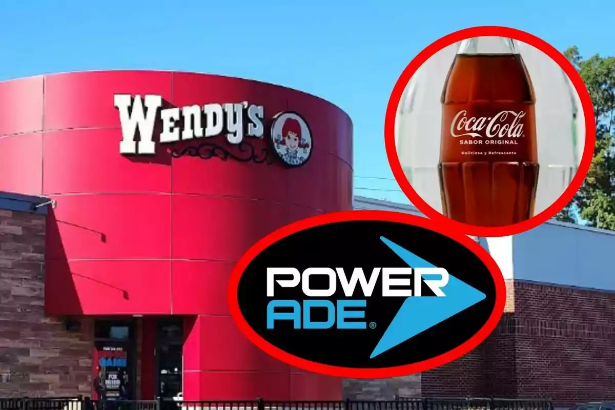 Façana d’un restaurant Wendy’s amb un cercle que mostra una ampolla de Coca-Cola i el logotip de Powerade en primer pla. Façana d’un restaurant Wendy’s amb un cercle que mostra una ampolla de Coca-Cola i el logotip de Powerade en primer pla.