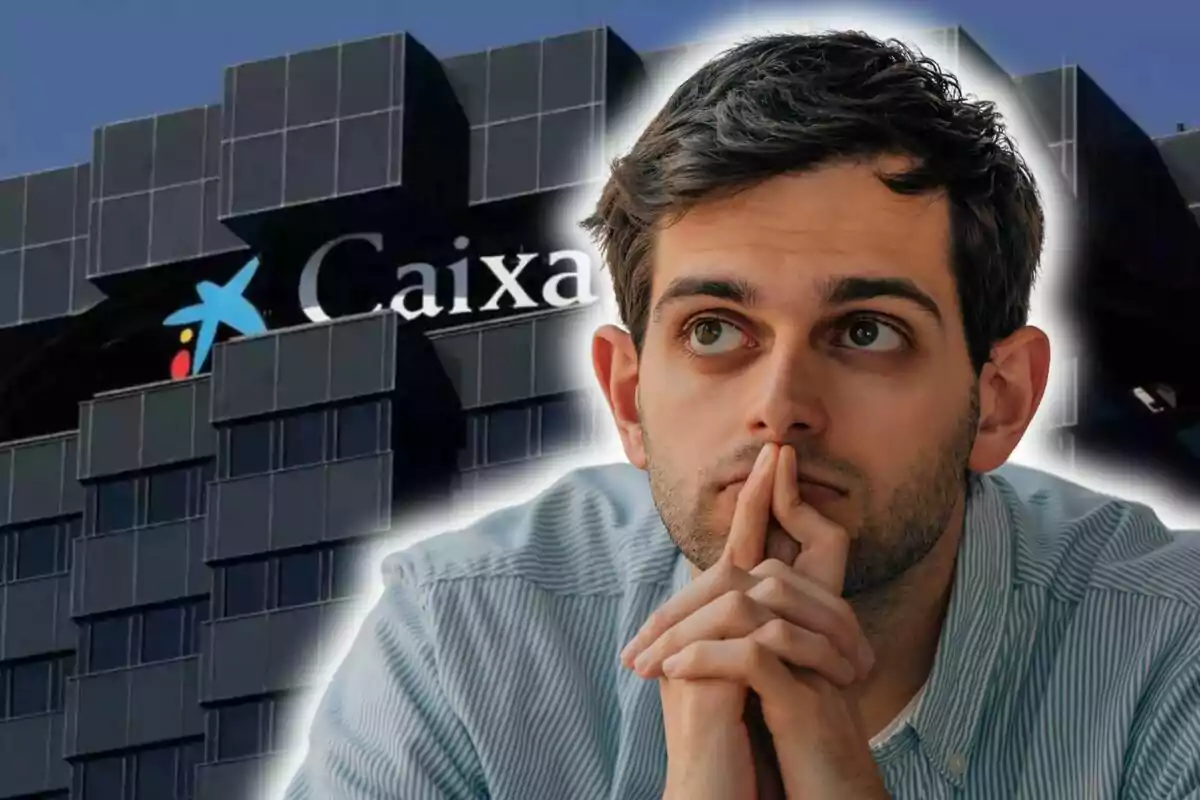 Un home pensatiu amb les mans juntes davant d?un edifici de CaixaBank.