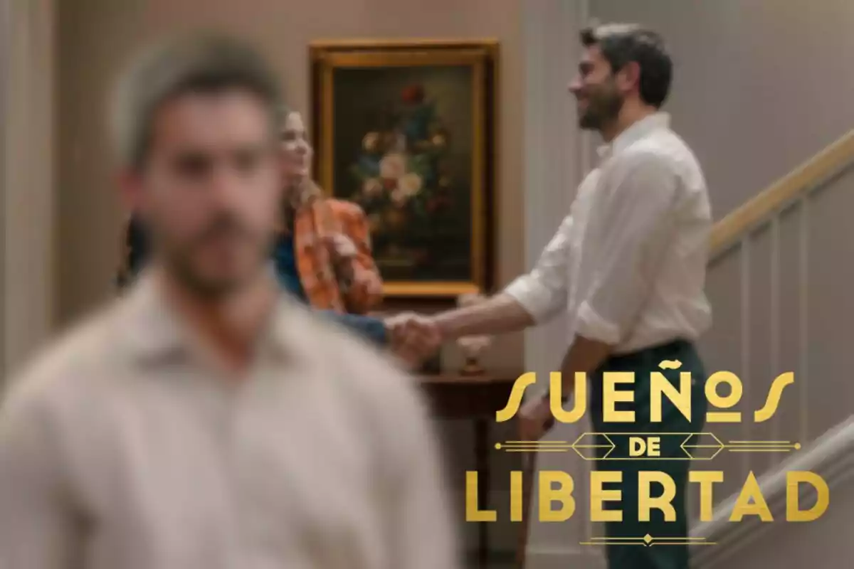 Una imatge amb el títol "Somnis de Llibertat" a la part inferior dreta, una escena de la sèrie mostrant dues persones donant-se la mà al fons i Andrés desenfocat en primer pla.