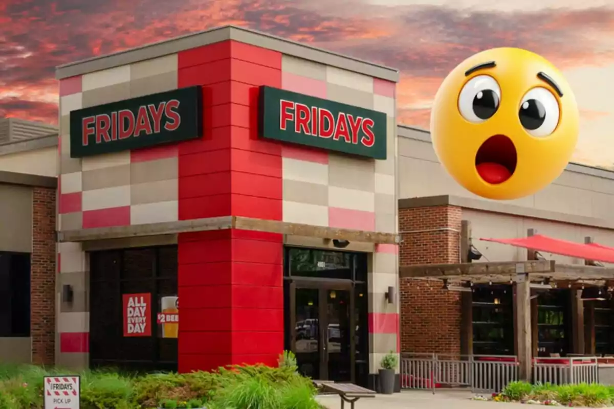 A Fridays restaurant with a big surprised emoji floating in the sky at sunset. A Fridays restaurant with a big surprised emoji floating in the sky at sunset.