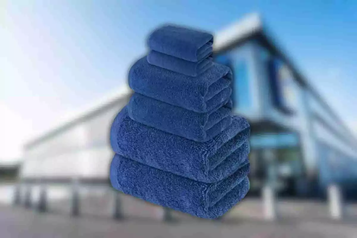 Un conjunto de toallas azules apiladas frente a un edificio moderno. Un conjunto de toallas azules apiladas frente a un edificio moderno.