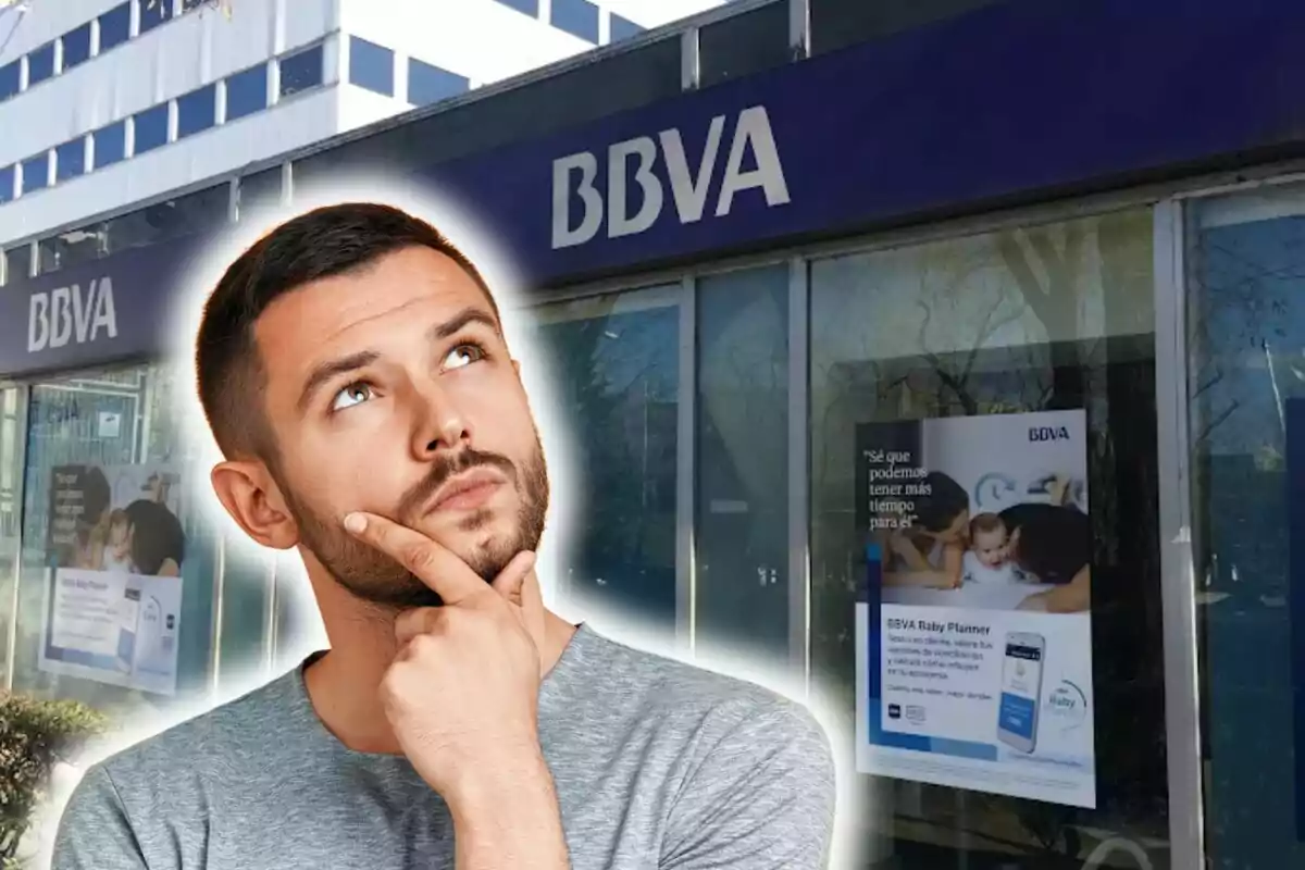 Un home pensatiu davant d'una sucursal del BBVA.