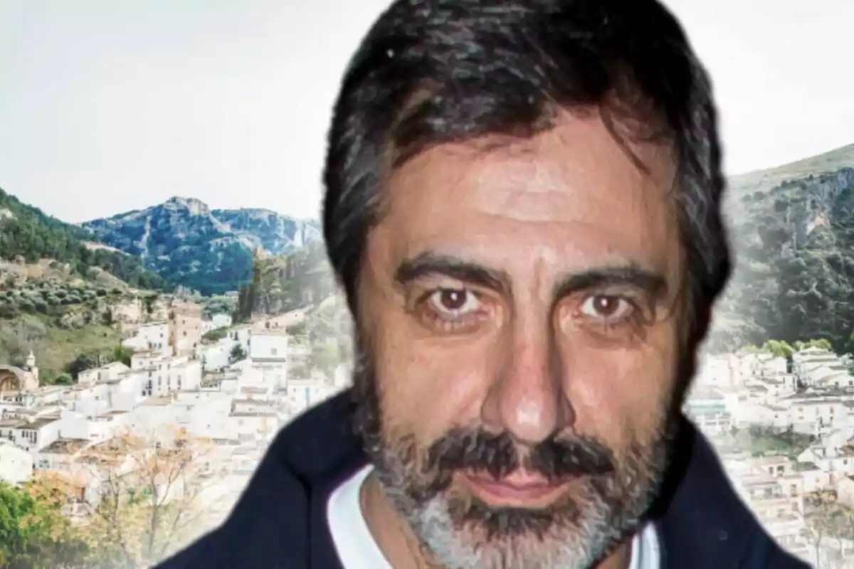 Primer pla de Juan del Val amb un poble blanc i muntanyes al fons, que és Cazorla (Jaén).