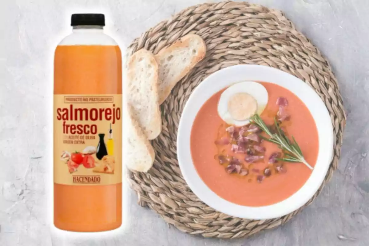Una ampolla de salmorejo fresc al costat d'un plat servit amb ou dur, pernil i pa sobre un estovalles de vímet. Una ampolla de salmorejo fresc al costat d'un plat servit amb ou dur, pernil i pa sobre un estovalles de vímet.
