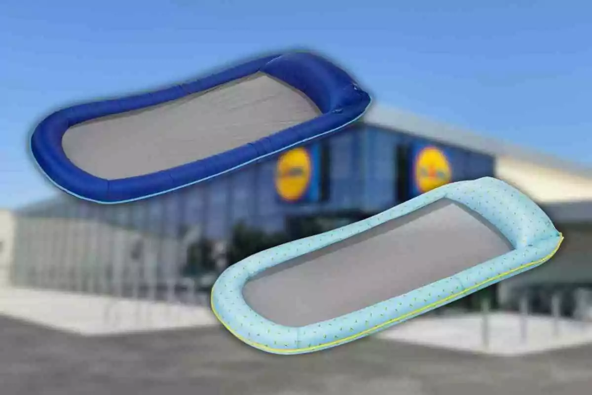 Dos colchonetas inflables para piscina, una azul y otra celeste con puntos, flotando frente a una tienda con el logo de Lidl desenfocado al fondo Dos colchonetas inflables para piscina, una azul y otra celeste con puntos, flotando frente a una tienda con el logo de Lidl desenfocado al fondo