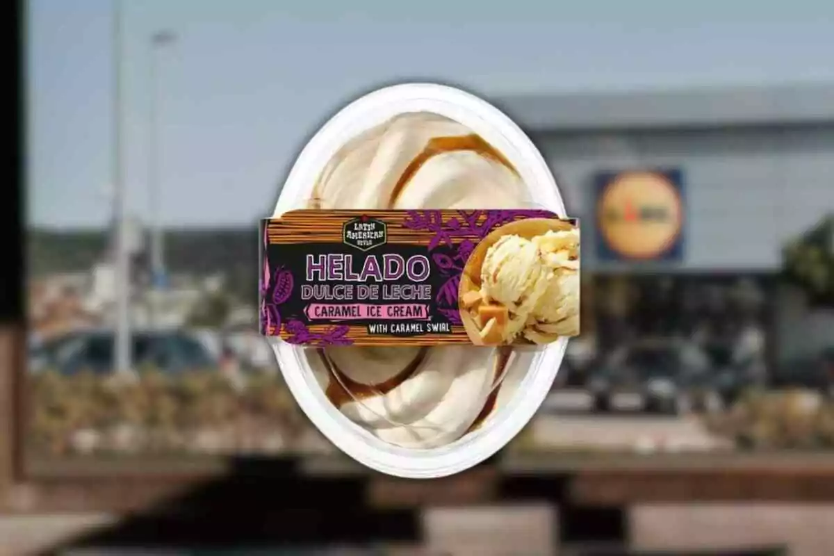 Envàs de gelat de dolç de llet amb remolins de caramel i etiqueta colorida al davant, amb un supermercat desenfocat de fons Envàs de gelat de dolç de llet amb remolins de caramel i etiqueta colorida al davant, amb un supermercat desenfocat de fons