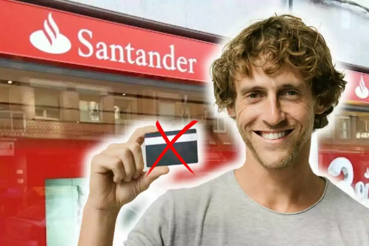 Un home somrient sosté una targeta ratllada davant d'una sucursal del banc Santander.